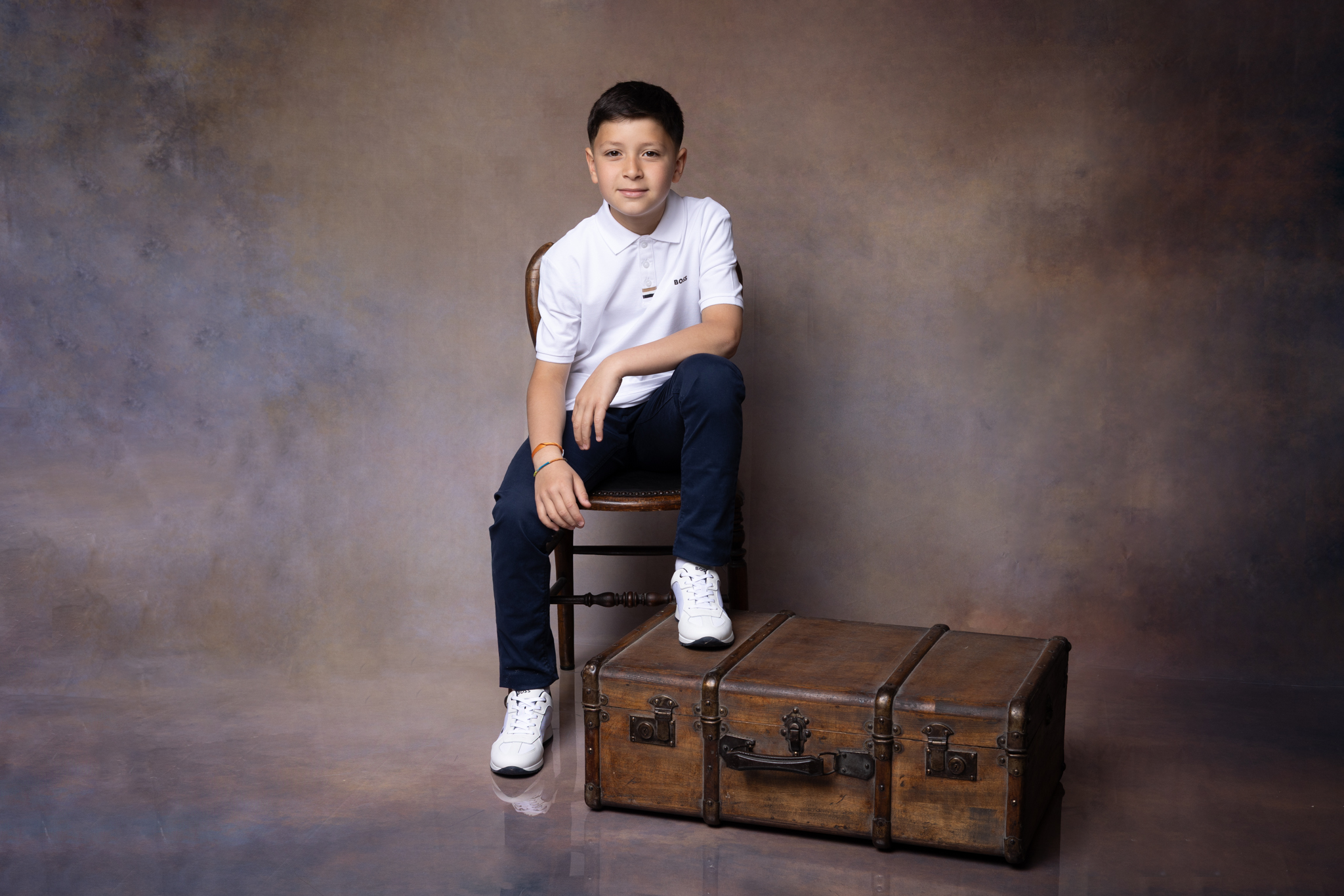 photo d'un garçon en studio sur un fond marron pour sa communion