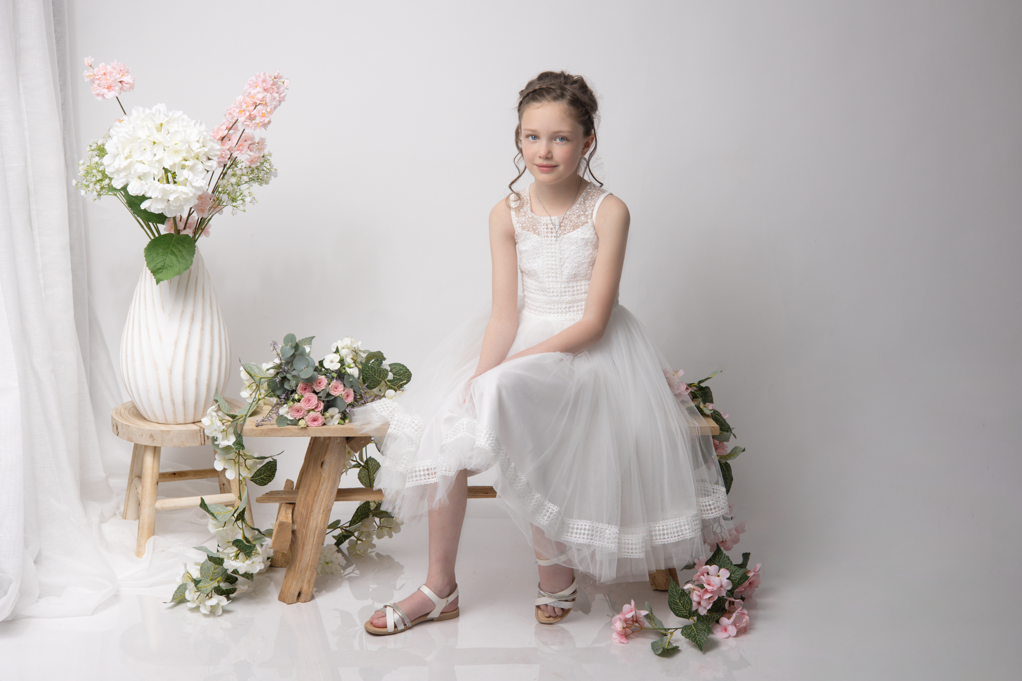 photo d'une fillette en studio pour sa communion sur un fond blanc