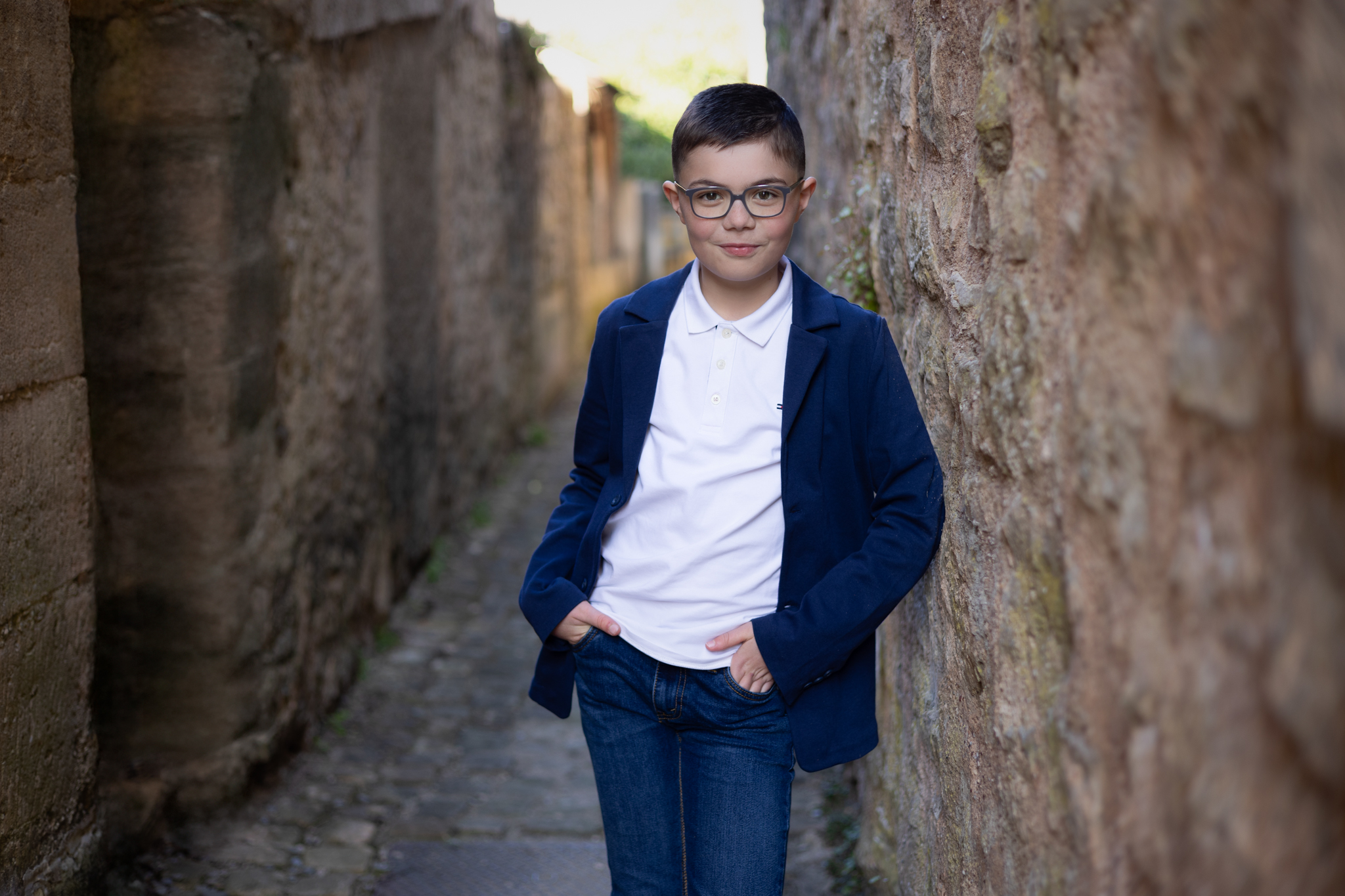 photo d'un garçon en extérieur avec des vieilles pierres pour sa communion 