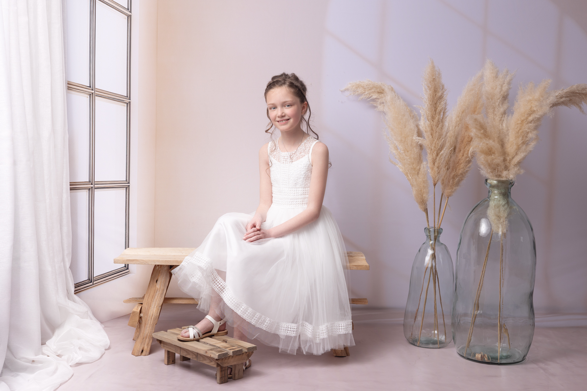 photo d'une fillette en studio sur un banc pour sa communion