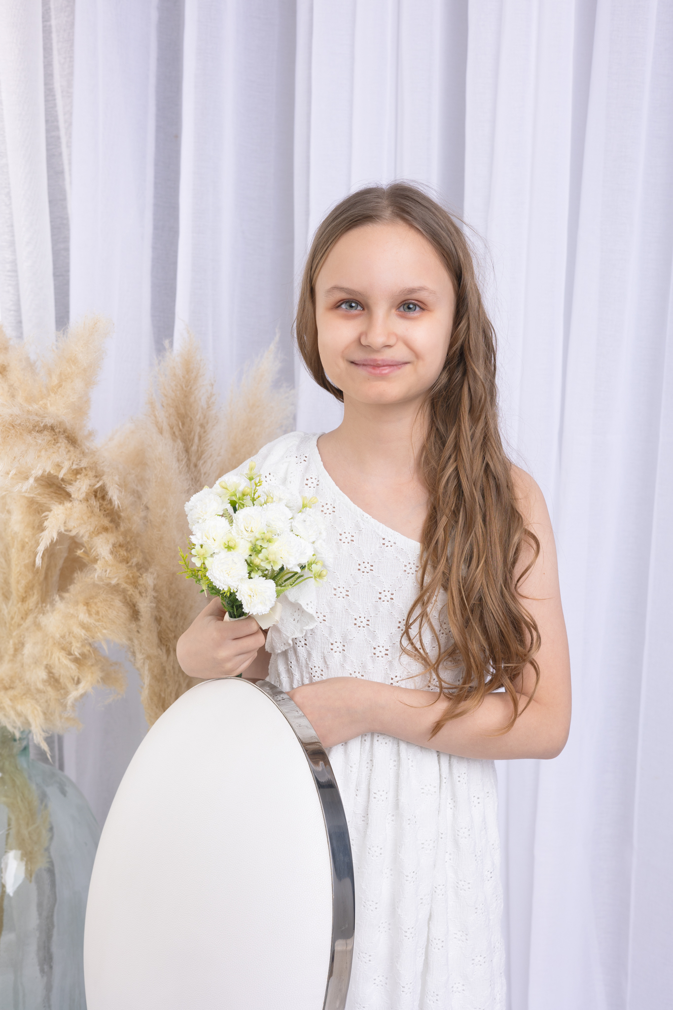 photo d'une fillette en studio pour sa communion avec un rideau blanc
