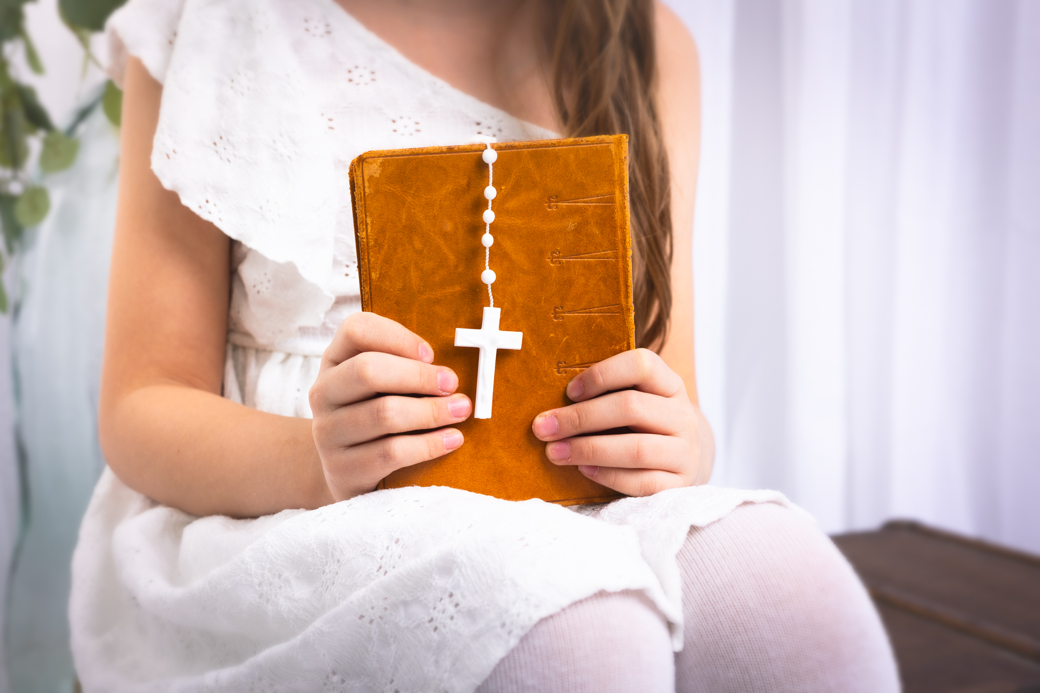 photo d'une bible dans les main d'une fillette pour sa communion