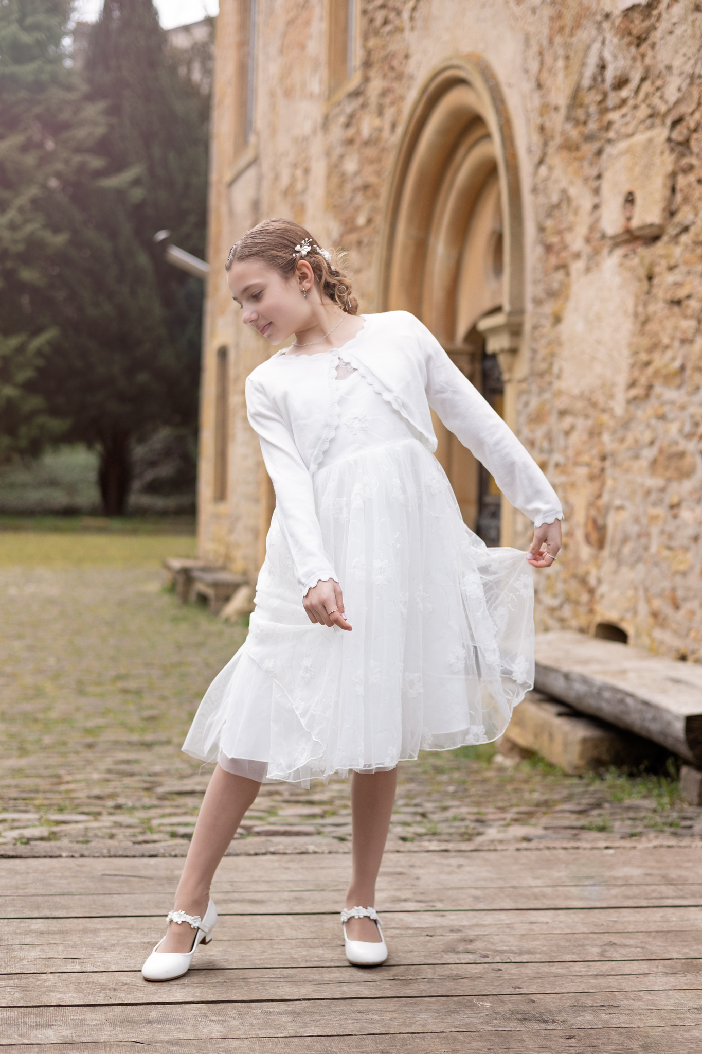 photo de communion d'une fille en extérieur avec de vieilles pierres