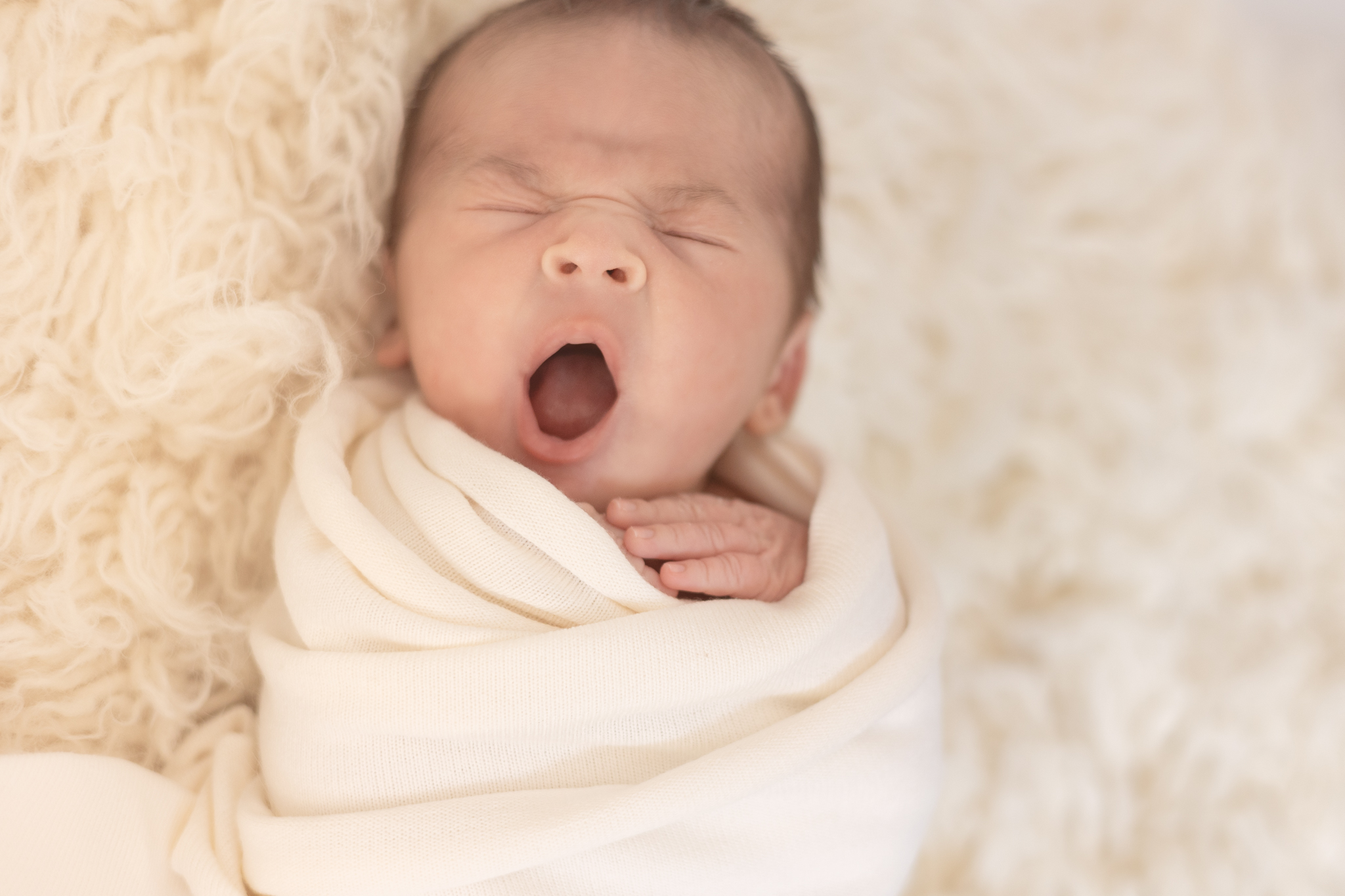 bébé qui baille lors d'une séance naissance en studio