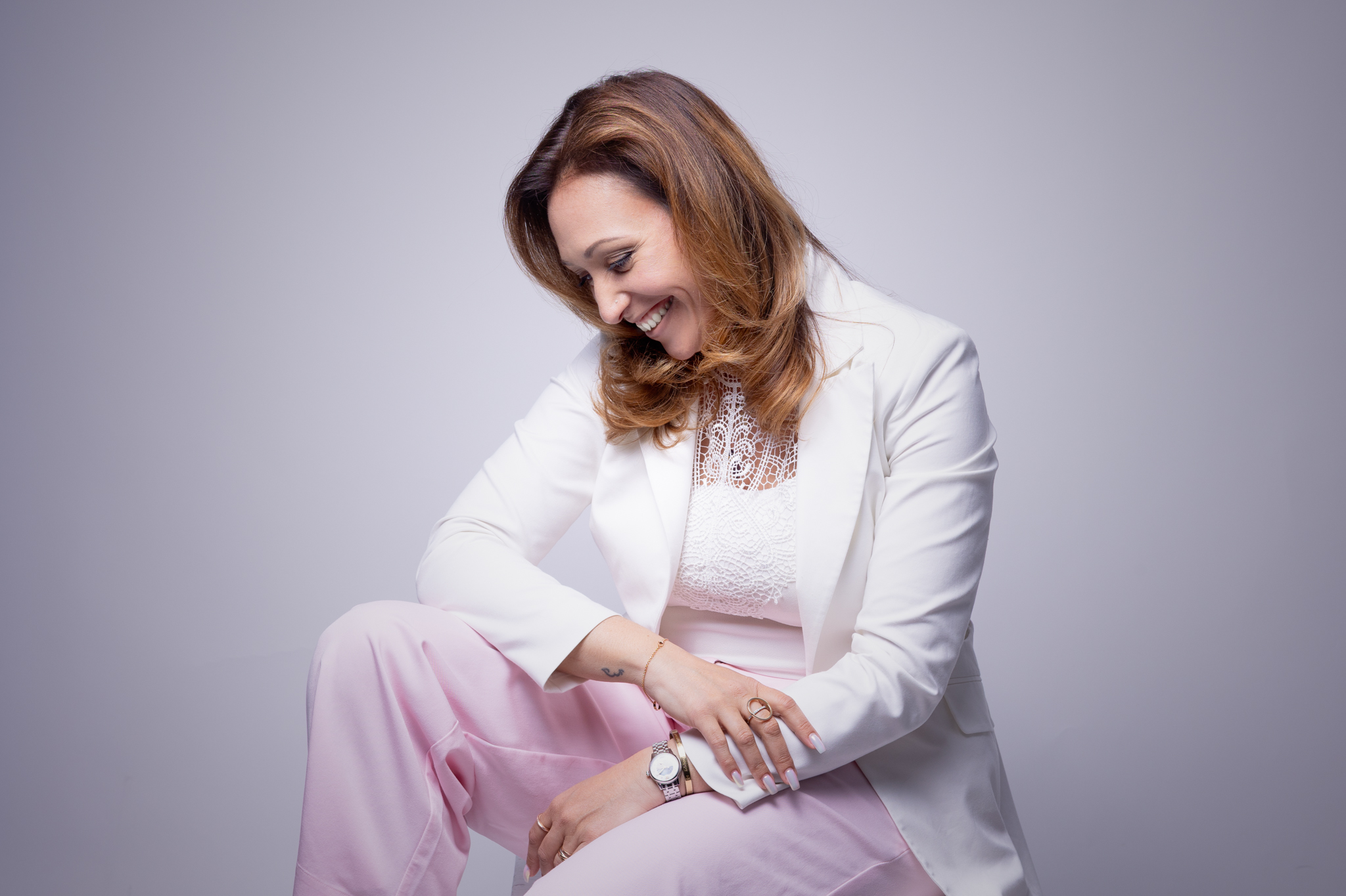 Photo de portrait de femme habillée en blanc et rose sur un fond gris en studio