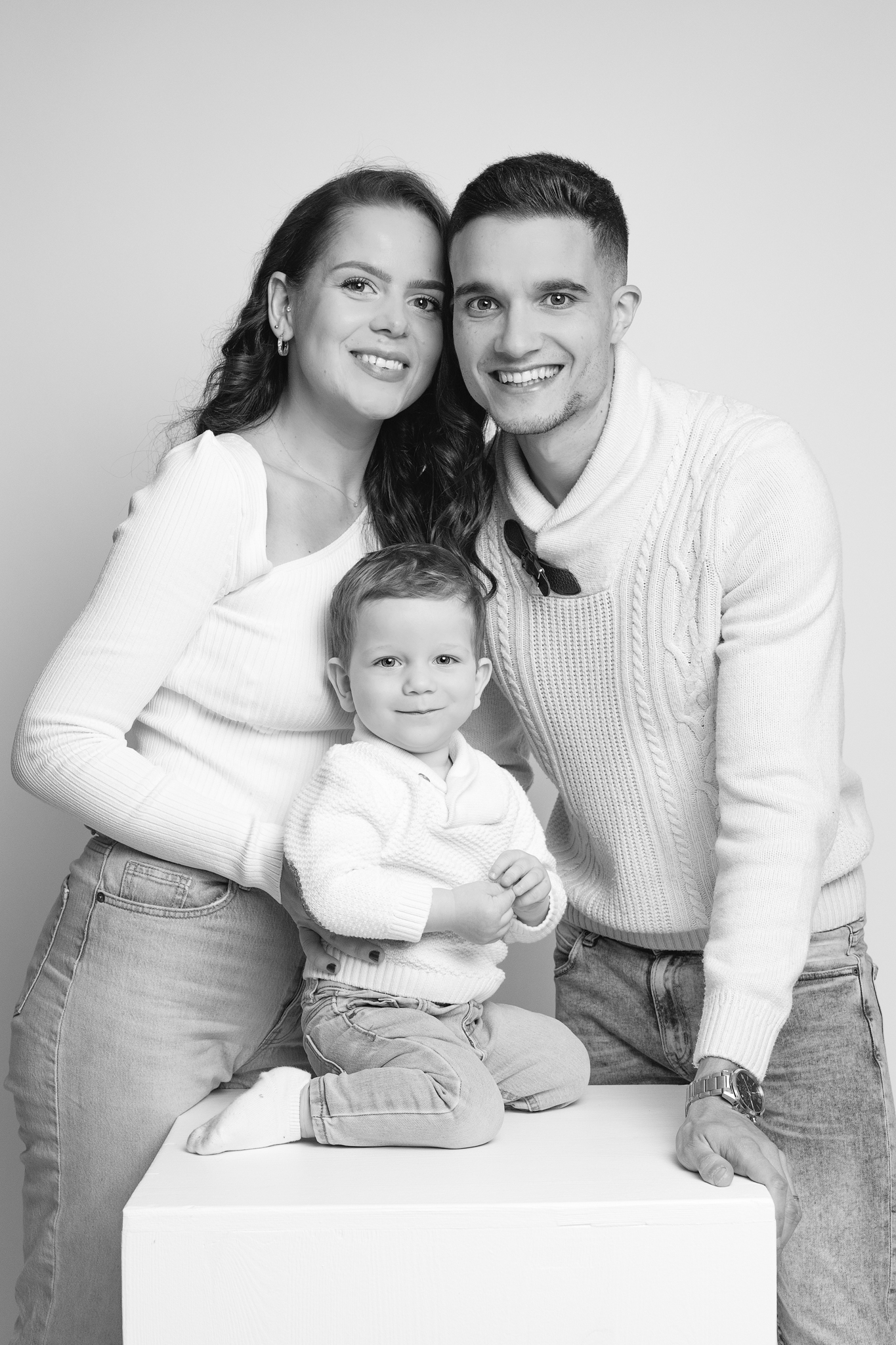 photo de famille en studio , tous habillés en jeans et pull blanc