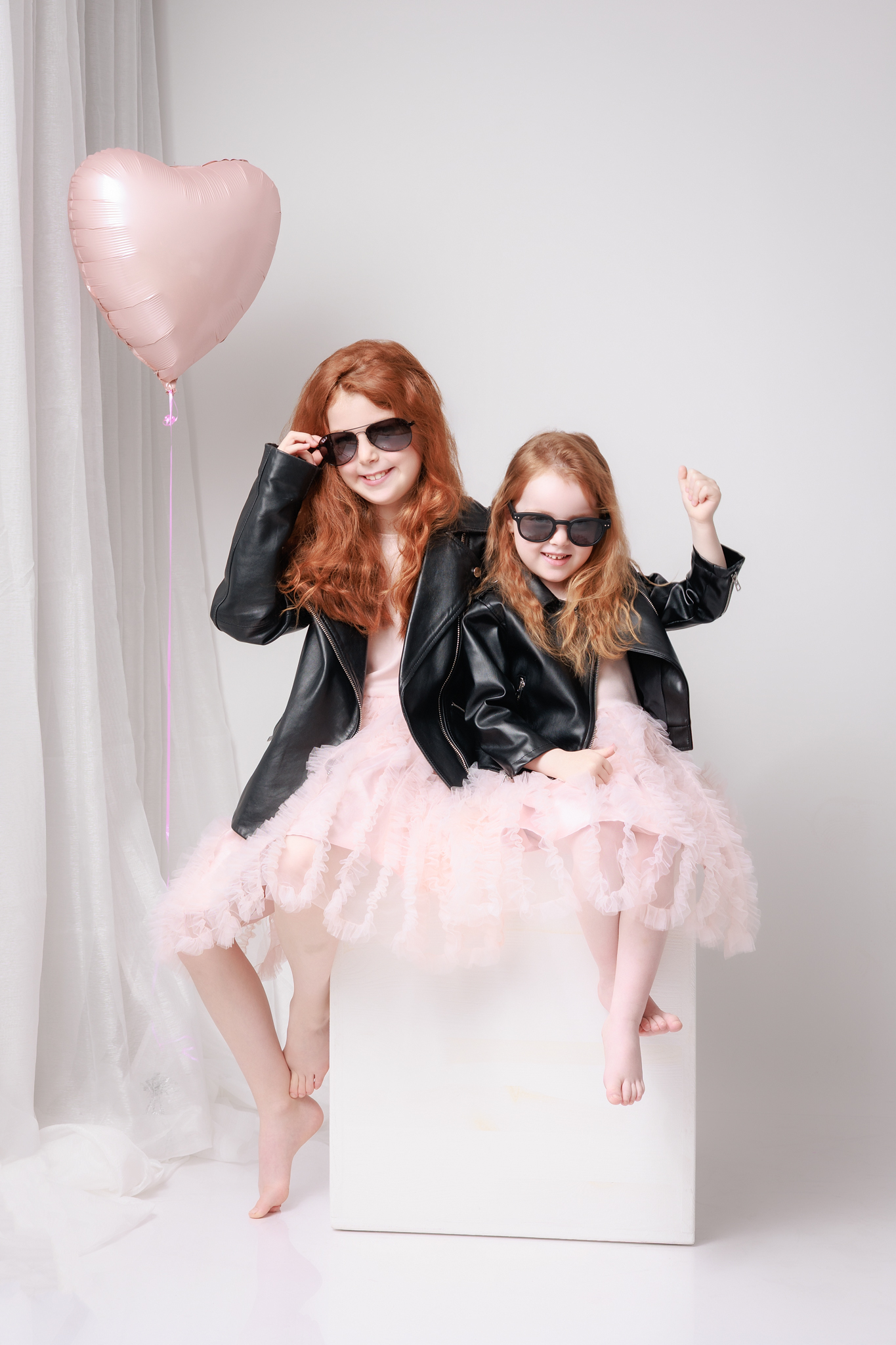 une photo en studio de deux soeurs avec un ballon à l'hélium