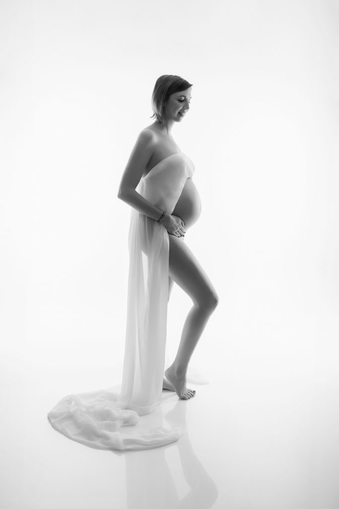 femme enceinte en studio photo avec un voile blanc