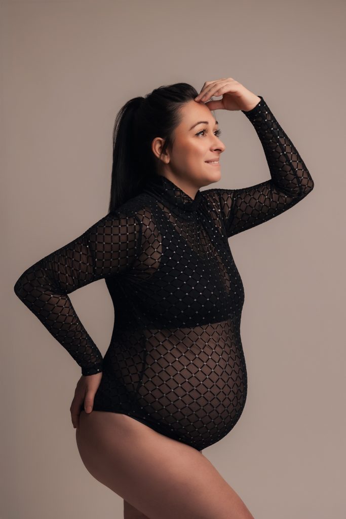 Femme enceinte en body pour un shooting en studio