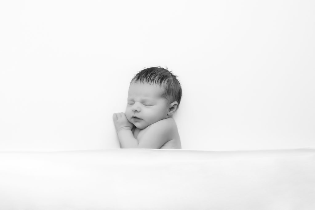 photo en noir et blanc d'un bébé tout simplement posé