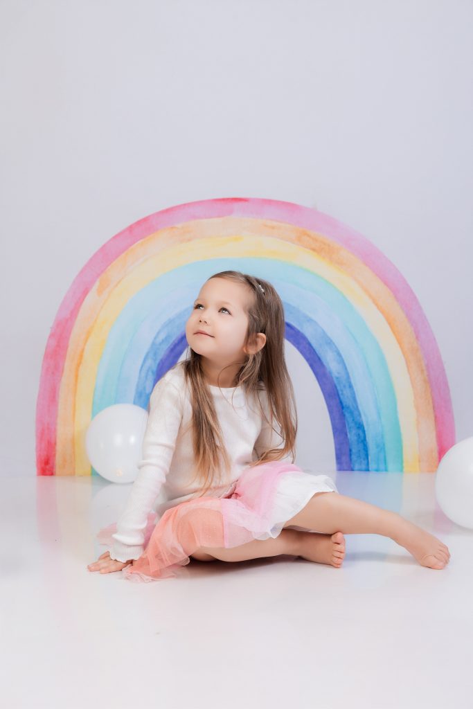 fille en studio avec un décor arc en ciel en arrière plan