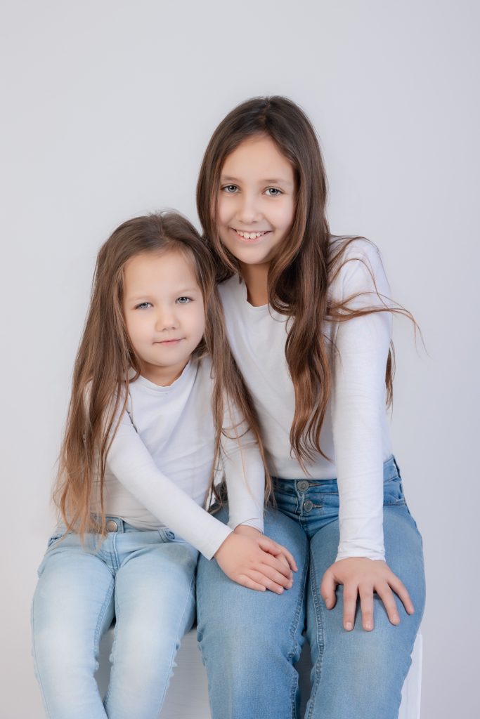 Deux soeurs en studio photo , en jeans et tee shirt blanc