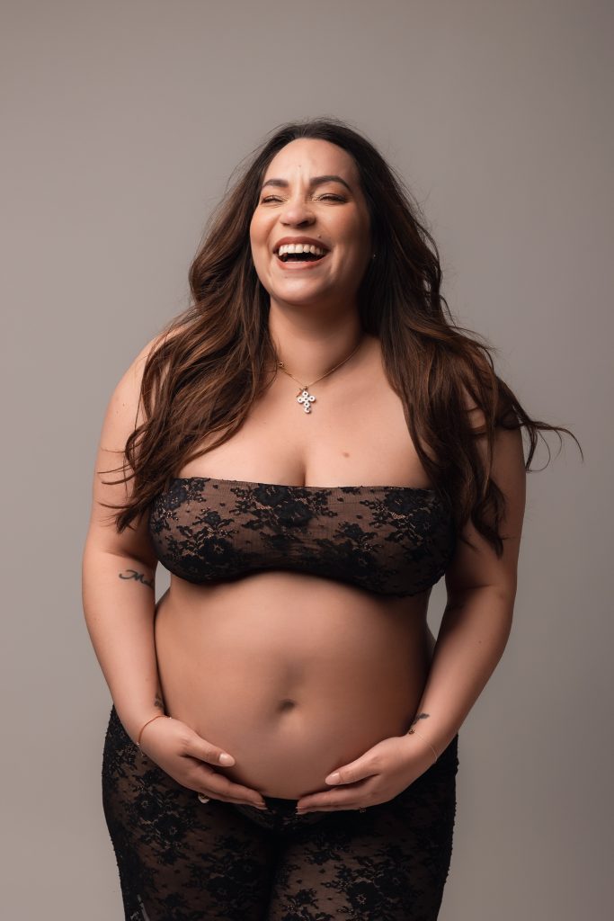 future maman qui éclate de rire en studio habillée en dentelle 